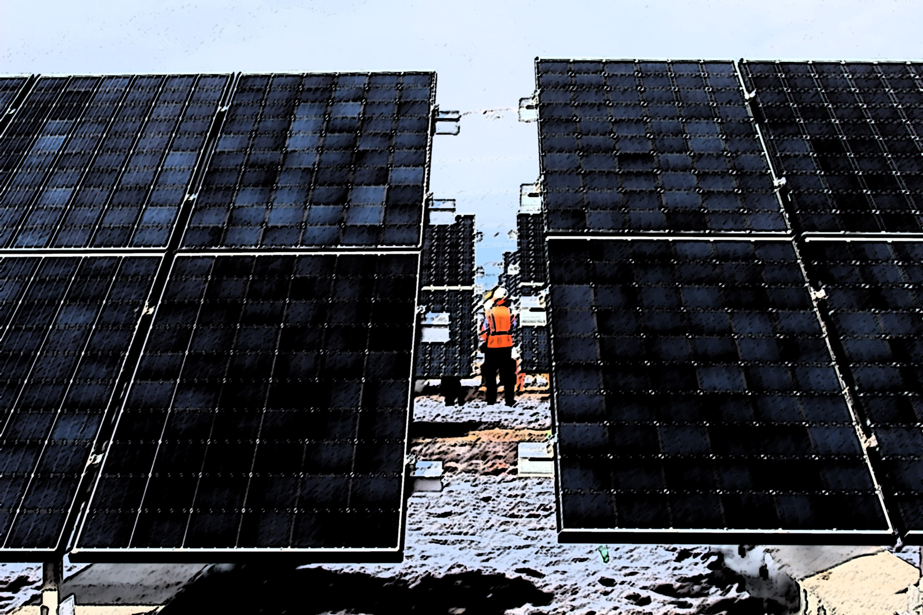 A construction worker standing amid a newly-built solar array.
